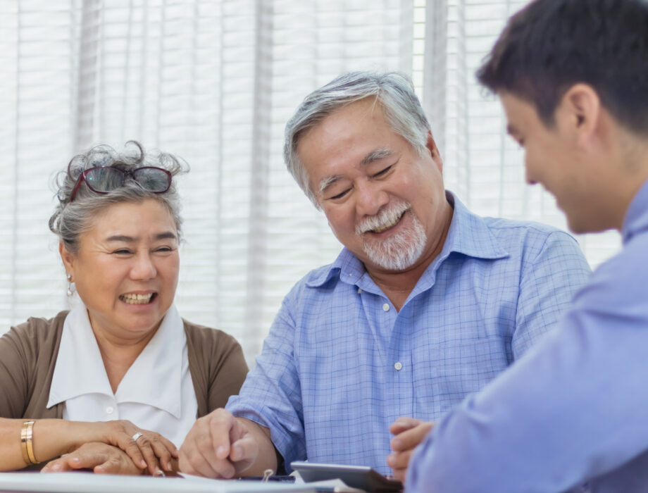 Older couple reviewing care options with a healthcare professional, representing a family discussion about assisted living and skilled nursing.